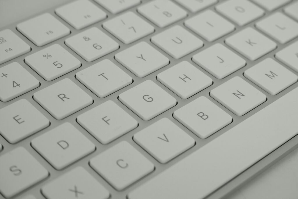 Detailed close-up of a sleek white keyboard, emphasizing modern technology.